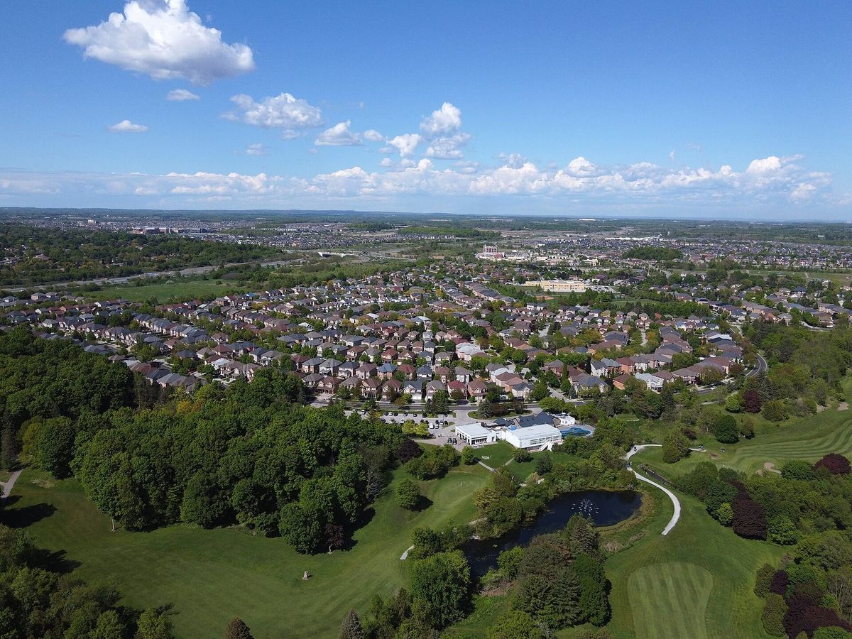 Aerial view of the Box Grove neighbourhood in Markham, with homes, woodland and a golf course.