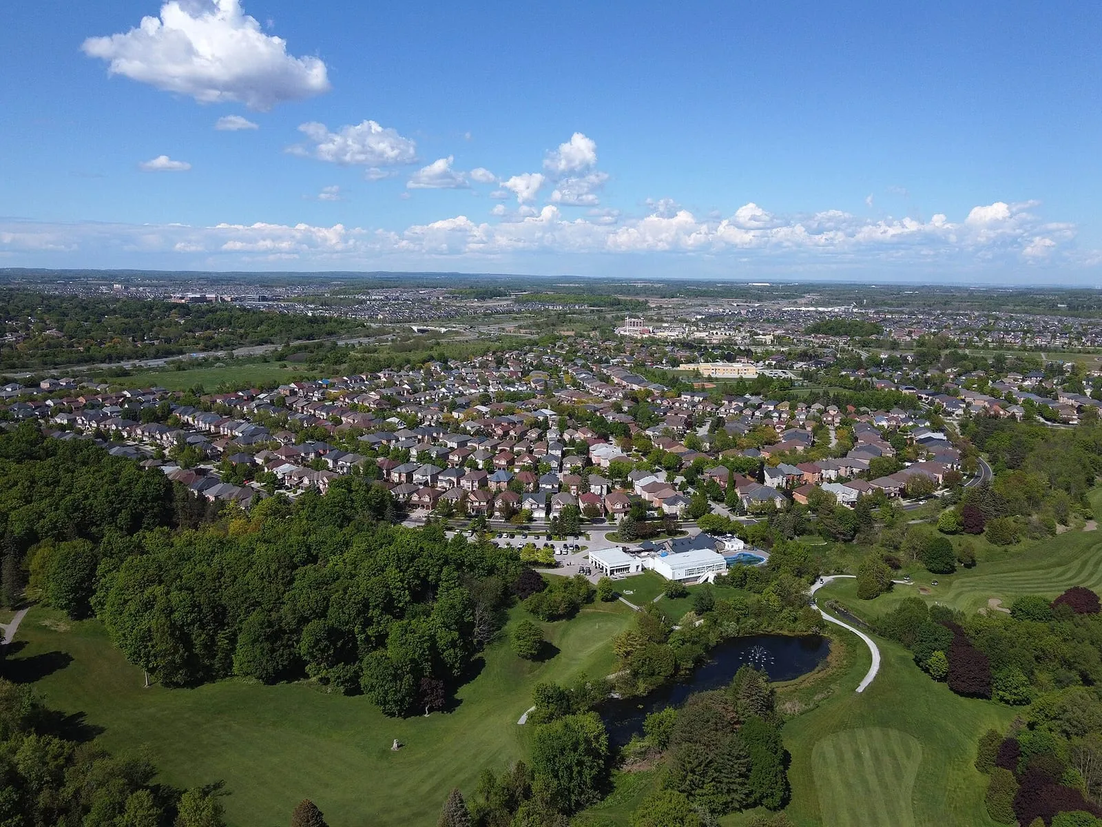 Aerial view of the Box Grove neighbourhood in Markham, with homes, woodland and a golf course.
