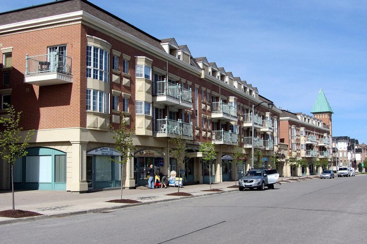 Low-rise apartment buildings with ground-floor shops along Cornell Park Avenue in Cornell, Markham.