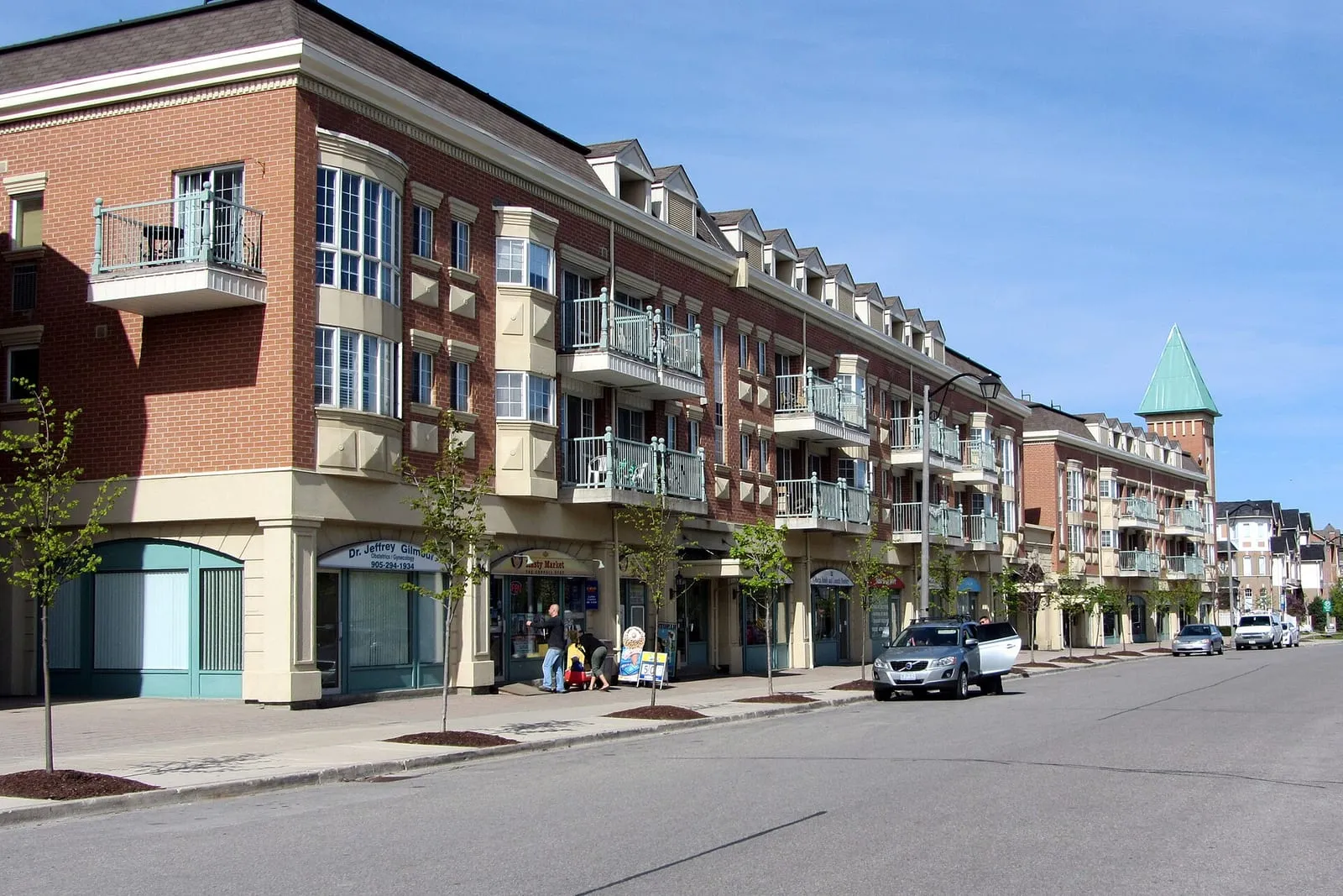 Low-rise apartment buildings with ground-floor shops along Cornell Park Avenue in Cornell, Markham.