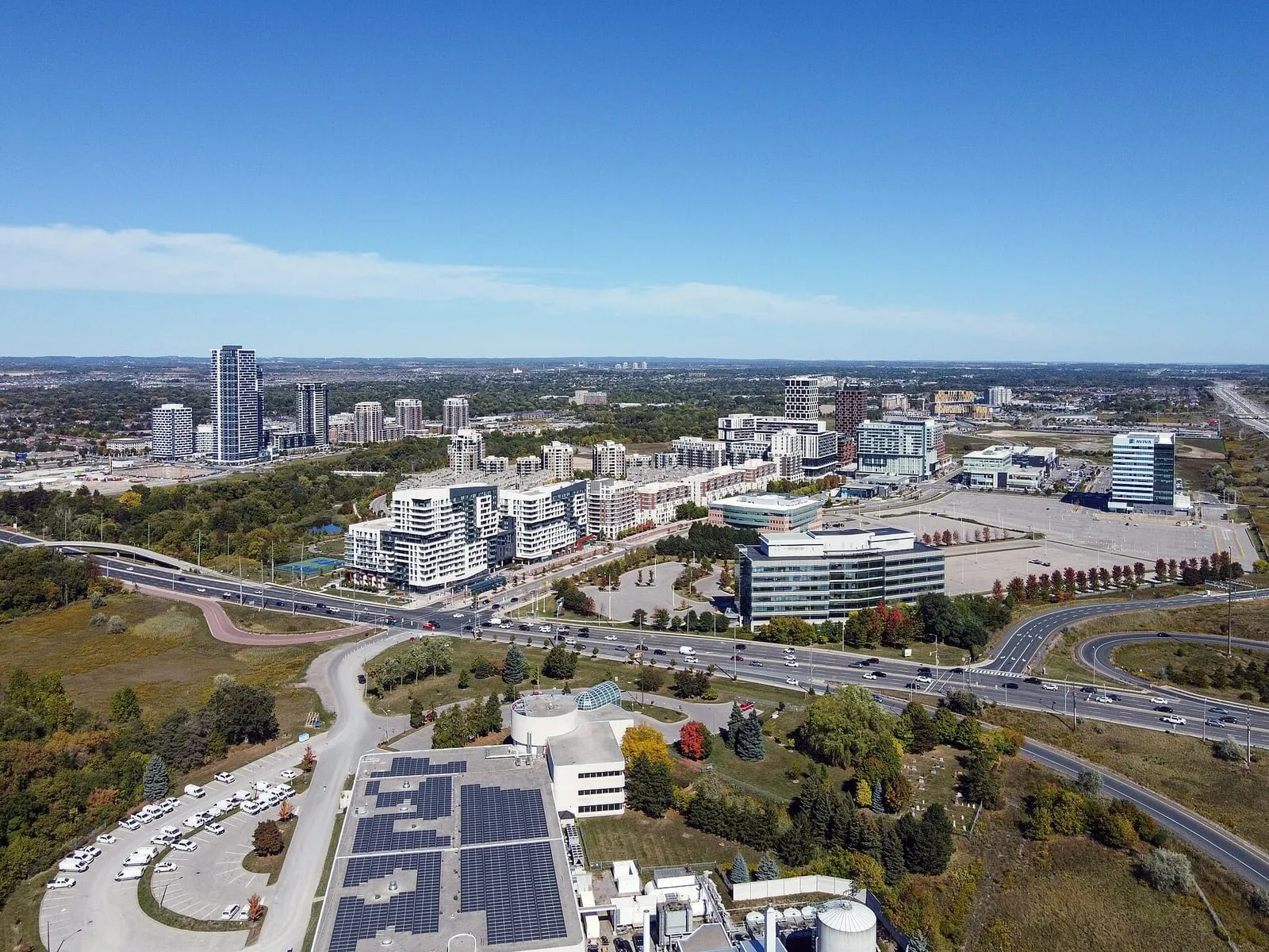 Aerial view of Downtown Markham condo towers and offices beside Highway 407 on a sunny day.