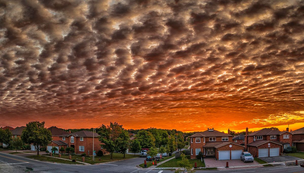 Sunset clouds over detached brick homes on a residential street in Richmond Hill, Ontario.