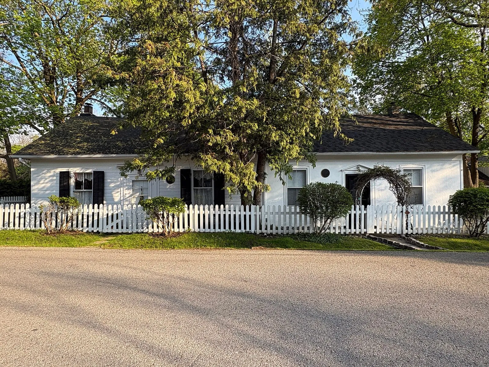 A white heritage house behind a picket fence on Colborne Street in the Thornhill Heritage Conservation District, Markham.